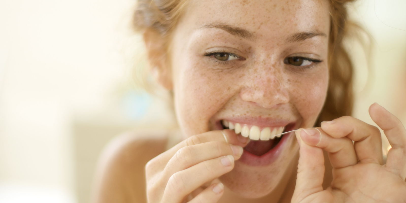 landscape 1429804747 woman flossing her teeth