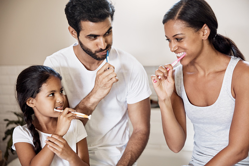 Family brushing teeth before oral hygiene checkup at Cooley Smiles 