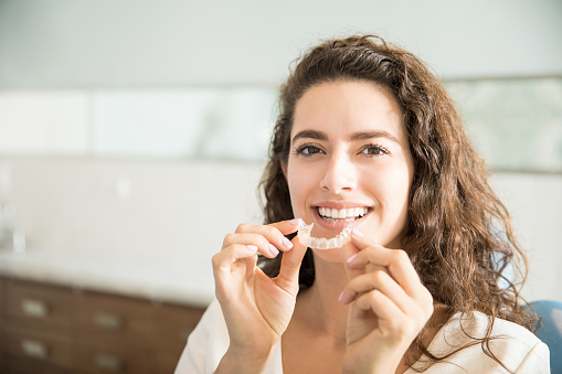 Woman smiling with Invisalign clear aligners at Cooley Smiles in Everett, WA