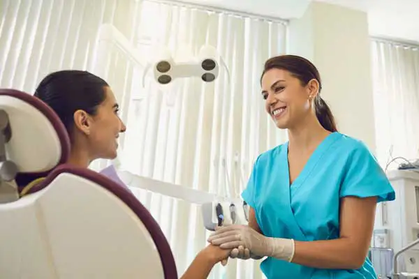 Dentist holding her patients hands and smiling at Jillian Prather Family Dentistry in Owasso, OK