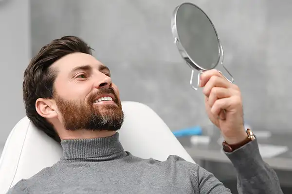 Smiling dental patient leaning back in exam chair and looking up into mirror at Cooley Smiles in Everett, WA