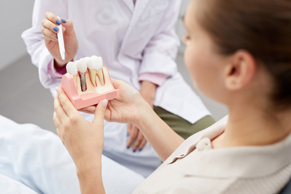 Dentist instructs patient with dental implant 3D model from Cooley Smiles in Everett, WA