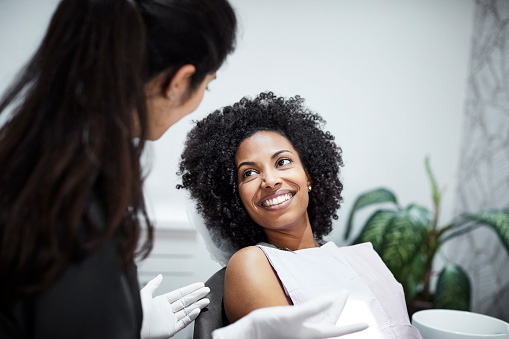Dentist speaking with a beautiful Black patient about Restorative Dentistry in Bellevue, Kenmore, and Everett, WACooley Smiles 