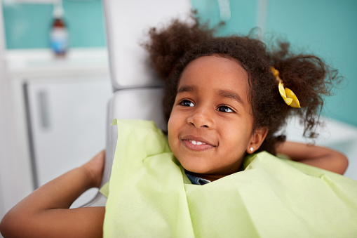 Adorable Black child smiling after getting denal sealants at Cooley Smiles 