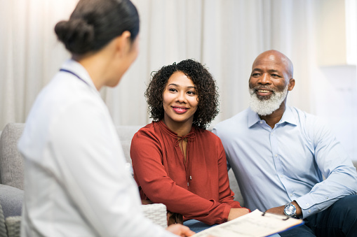 Dentist speaking with older Black couple regarding Bruxism from Cooley Smiles in Everett, WA 