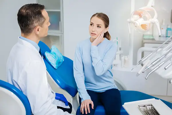 Concerned patient discussing her tooth pain with her dentist while sitting in a dental chair at Jillian Prather Family Dentistry in Owasso, OK