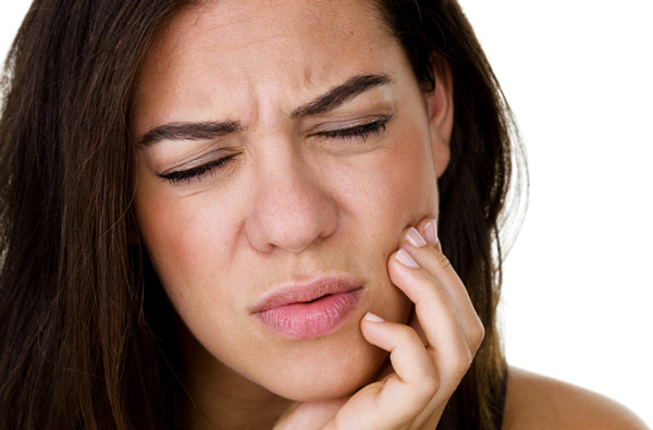 Woman holding jaw due to TMJ pain at Hoffman Dental in Hillsboro, OR