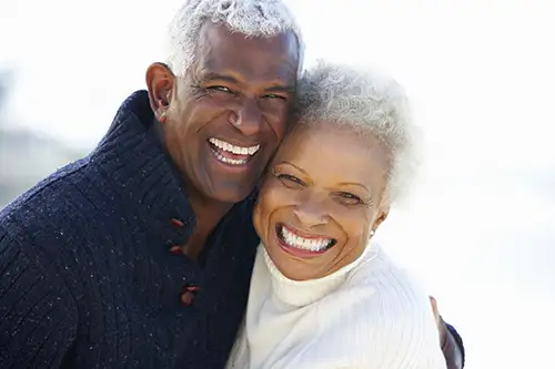 Older African American couple smiling with beautiful teeth from restorative dentistry services from Jillian Prather Family Dentistry in Owasso, OK