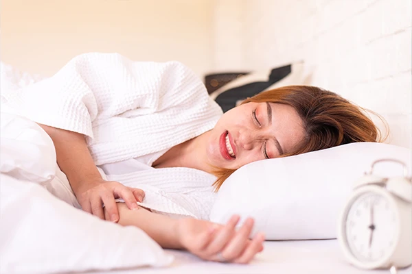 Stressed woman unconsciously grinding her teeth while sleeping on the bed before receiving treatment from Hoffman Dental in Hillsboro, OR
