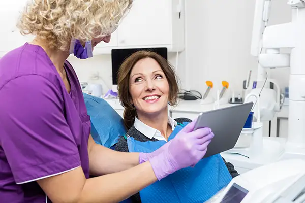 A smiling female patient interacting with her dentist at Hoffman Dental in Hillsboro, OR A smiling female patient interacting with her dentist at Hoffman Dental in Hillsboro, OR