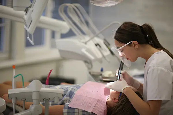 Dentist performing a restorative dental procedure on a patient in a modern dental clinic setting at Hoffman Dental in Hillsboro, OR