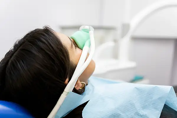 Patient receiving nitrous oxide sedation through a mask during a dental procedure at Hoffman Dental in Hillsboro, OR