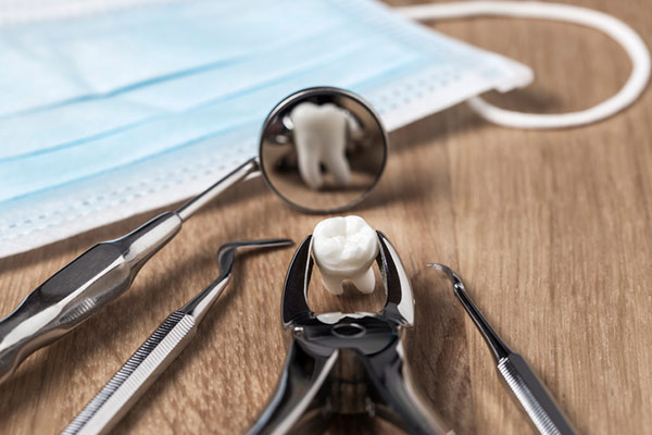 Extracted tooth and dental tools used for a tooth extraction at Cooley Smiles in Everett, WA